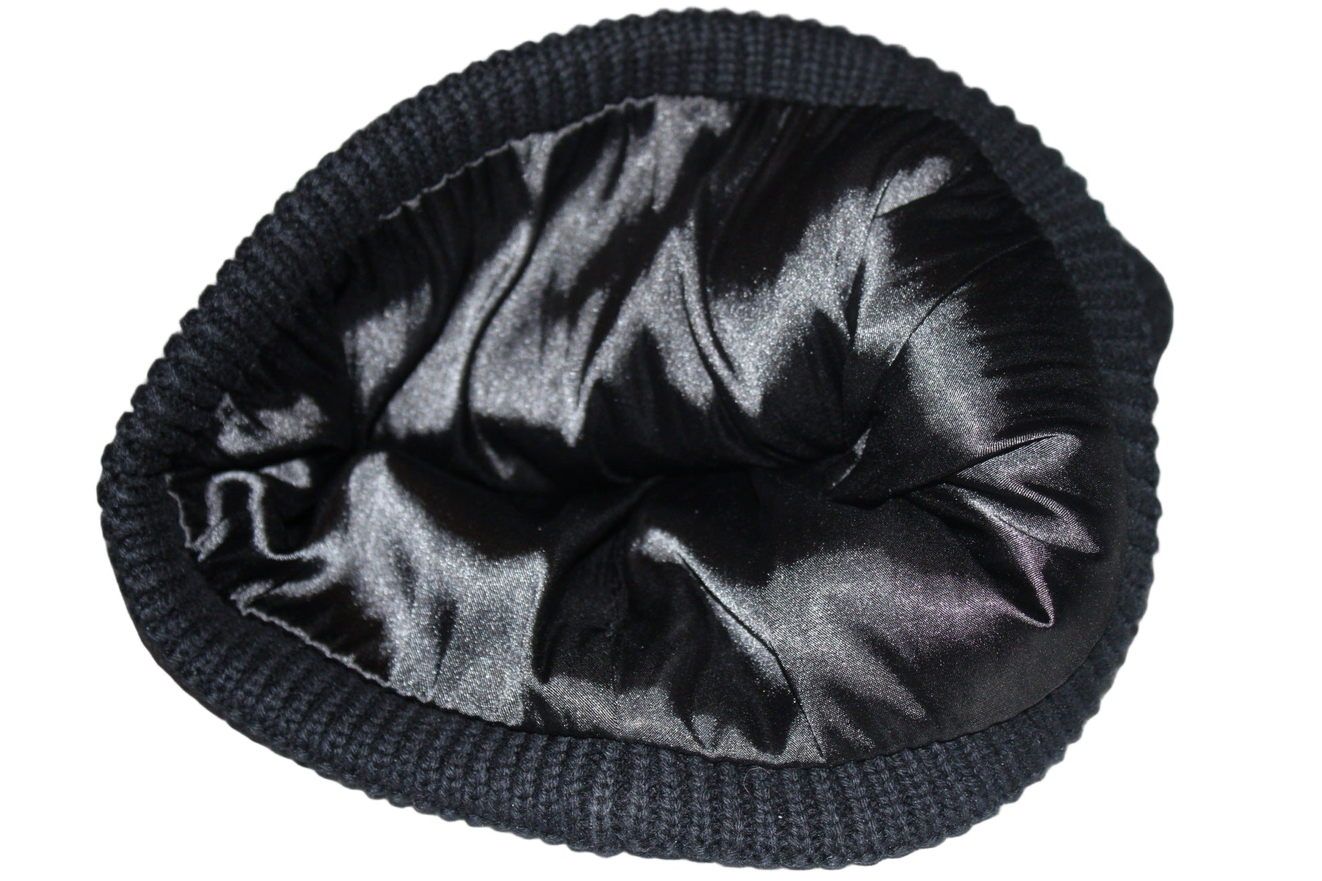 Black knit beanie with satin lining on a reflective surface