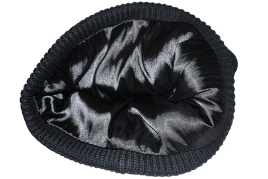 Black knit beanie with satin lining on a reflective surface