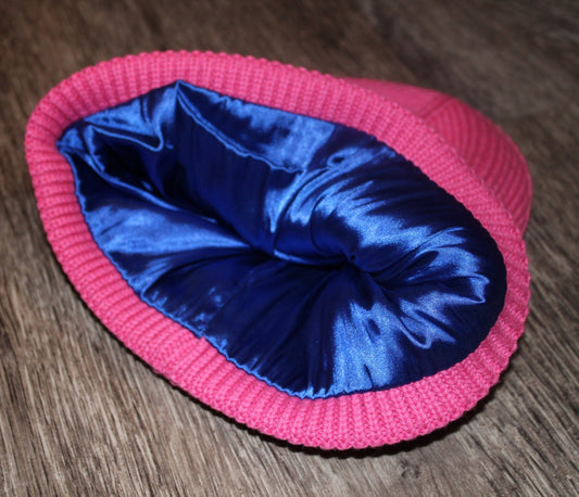 Pink beanie with blue satin lining on a wooden floor